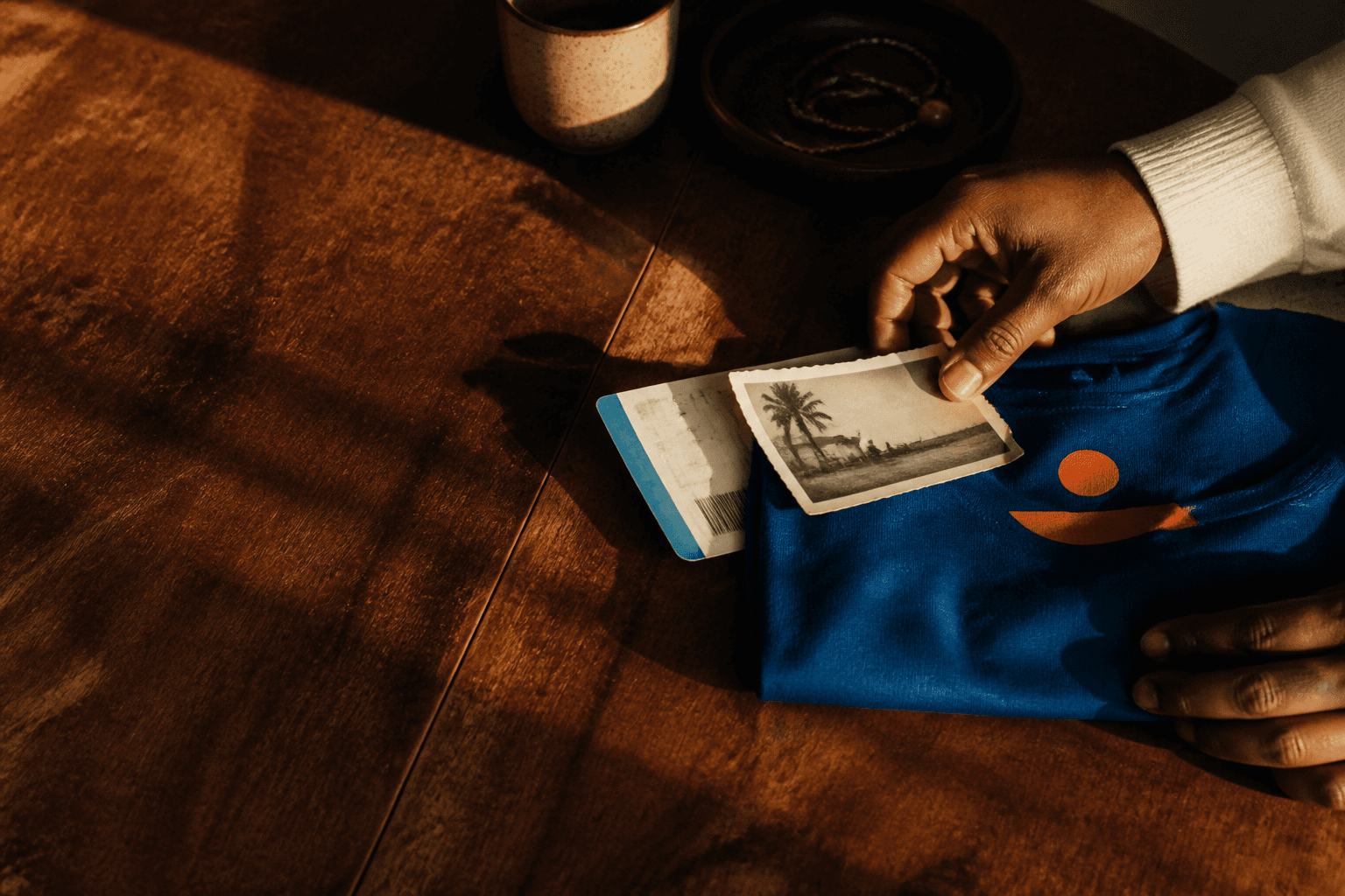 A t-shirt and personal travel mementos arranged on a table